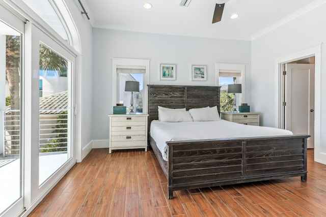 bedroom featuring access to outside, multiple windows, and wood finished floors