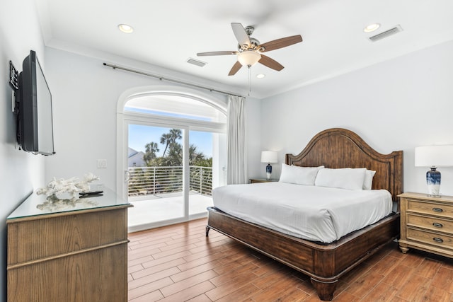 bedroom featuring access to outside, visible vents, and wood finished floors