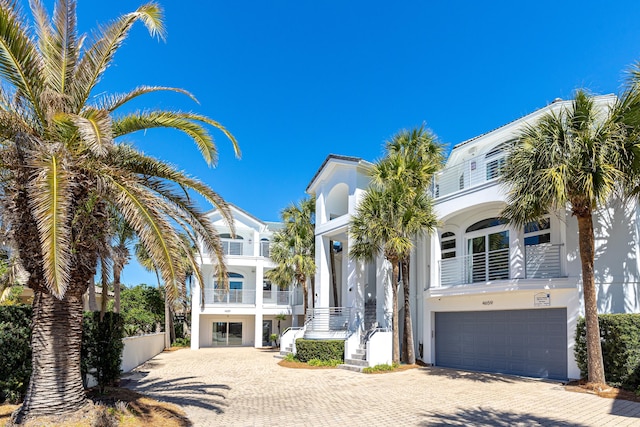 view of front of home with a garage, decorative driveway, and stucco siding