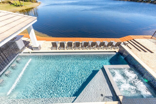 view of pool featuring a water view and a pool with connected hot tub