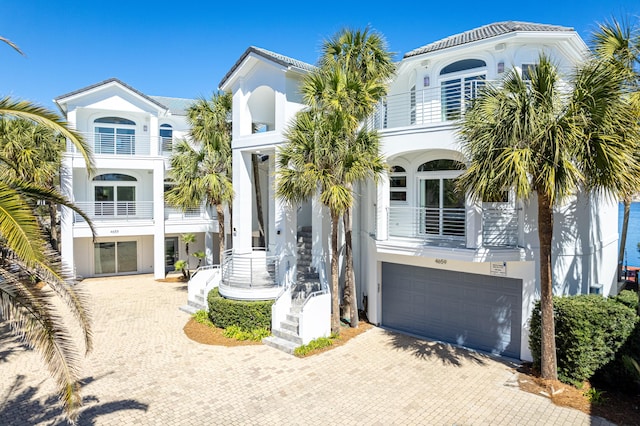 view of front of home featuring decorative driveway, an attached garage, and stucco siding