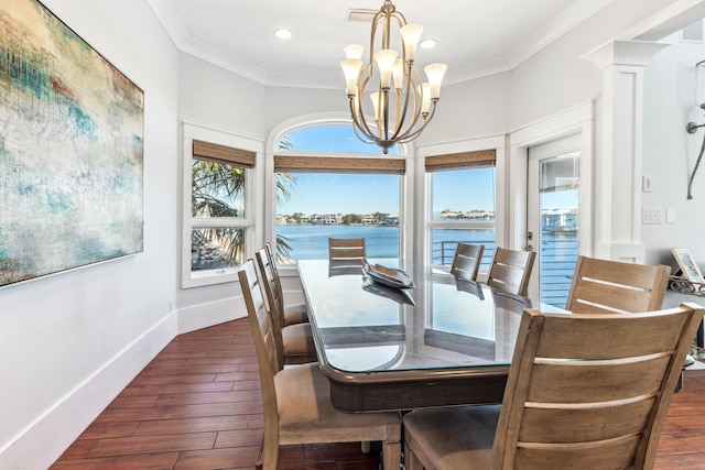 dining area featuring a chandelier, ornamental molding, and wood finished floors