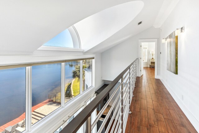 corridor featuring lofted ceiling, an upstairs landing, visible vents, baseboards, and dark wood-style floors