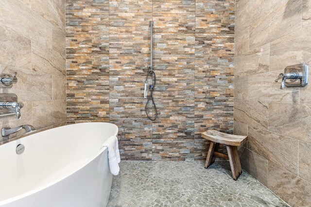 bathroom featuring a soaking tub and tiled shower