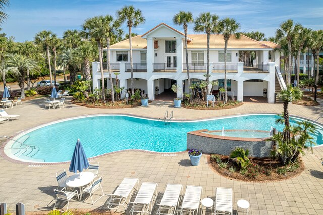 pool with a patio area, a jacuzzi, and french doors