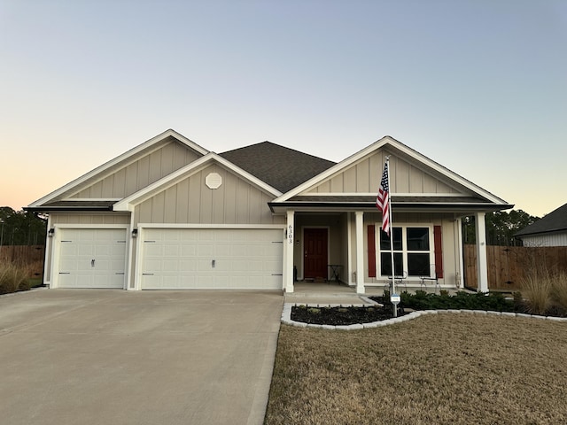 ranch-style home featuring concrete driveway, an attached garage, fence, a porch, and board and batten siding