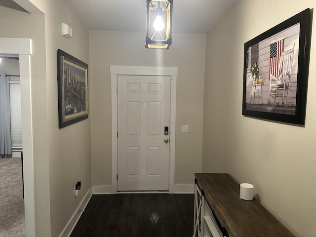 entryway with baseboards and dark wood-type flooring