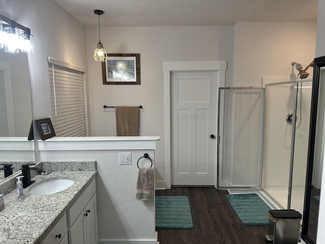 bathroom with a stall shower, wood finished floors, and vanity