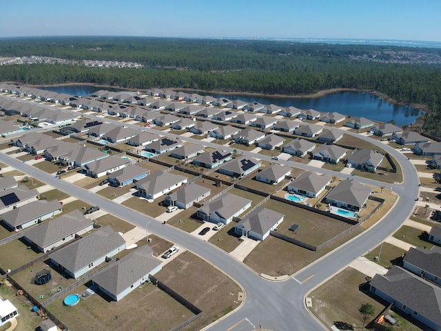 birds eye view of property featuring a water view, a residential view, and a view of trees