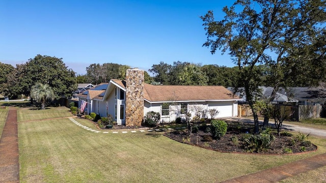 single story home featuring a chimney, a front yard, fence, a garage, and driveway