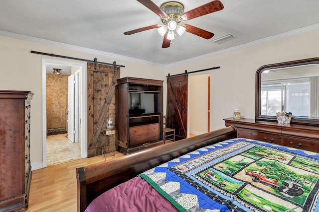 bedroom with ornamental molding, visible vents, and a barn door