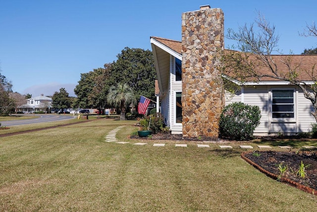 view of home's exterior featuring a lawn and a chimney