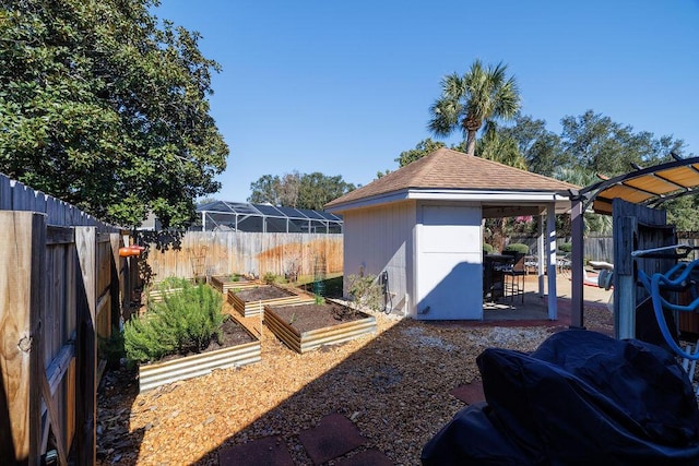 view of yard featuring a patio area, a garden, an outdoor structure, and a fenced backyard