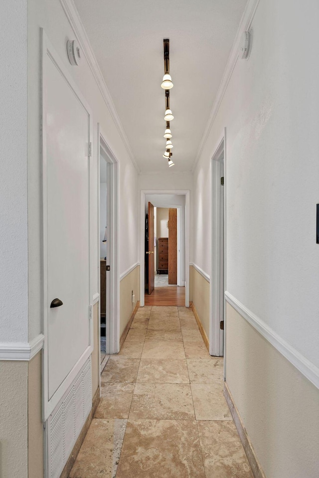 hall with baseboards and crown molding