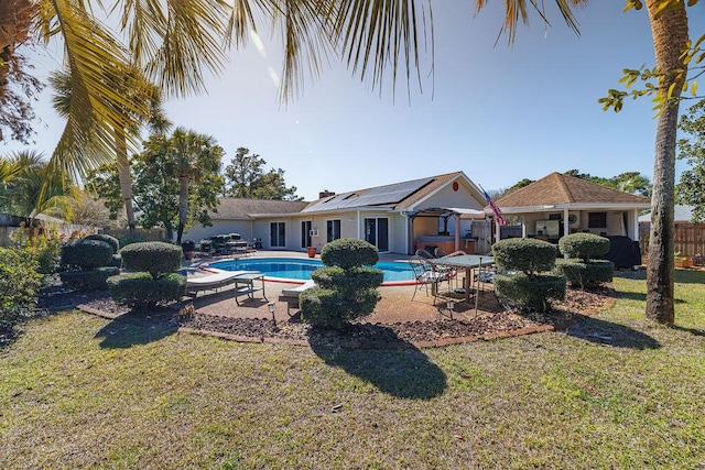 pool with a lawn, fence, and a patio