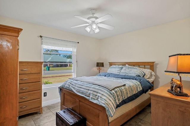 bedroom with light tile patterned floors, a ceiling fan, and baseboards