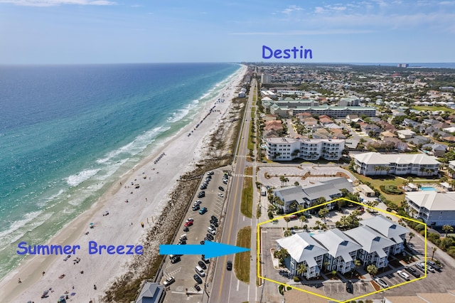 birds eye view of property with a water view and a beach view