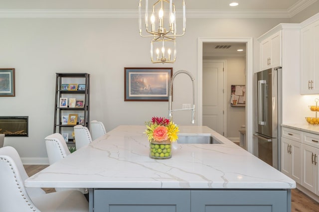 dining space featuring recessed lighting, visible vents, ornamental molding, light wood-type flooring, and an inviting chandelier