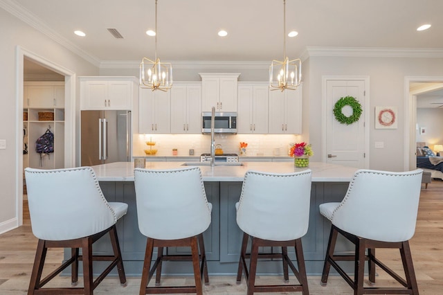 kitchen with a spacious island, white cabinetry, stainless steel appliances, and light wood-style floors