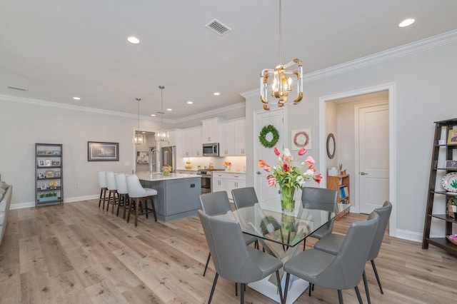 dining room featuring a chandelier, light wood-type flooring, and visible vents