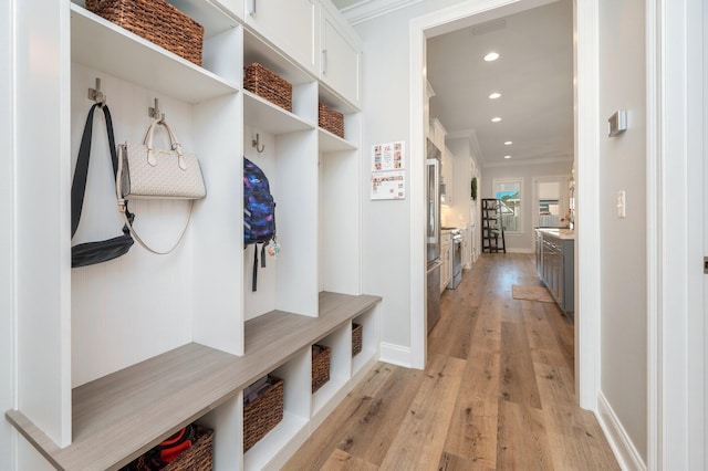 mudroom with recessed lighting, visible vents, ornamental molding, light wood-type flooring, and baseboards