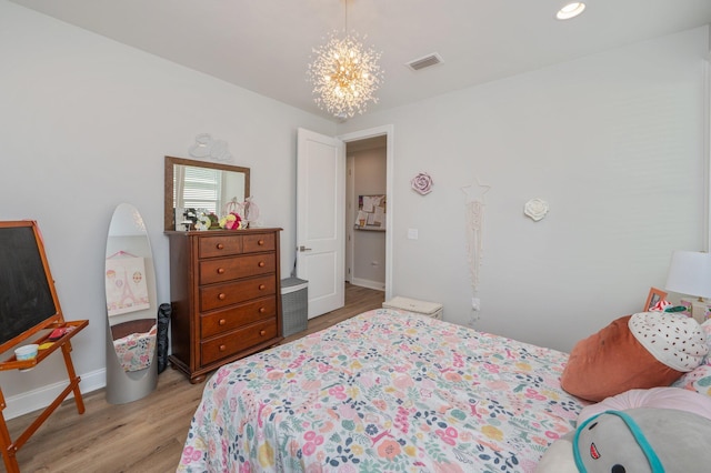 bedroom with light wood-type flooring, baseboards, visible vents, and a notable chandelier