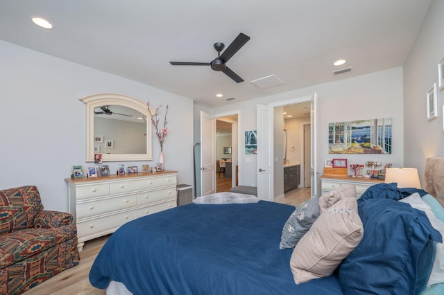 bedroom with ensuite bathroom, light wood finished floors, visible vents, and recessed lighting