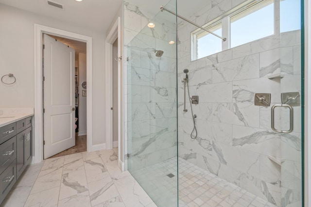 full bathroom featuring vanity, visible vents, baseboards, marble finish floor, and a marble finish shower