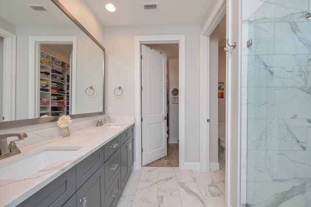 bathroom featuring marble finish floor, a sink, and visible vents