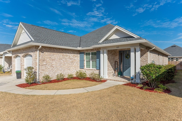 single story home featuring a shingled roof, brick siding, and a garage