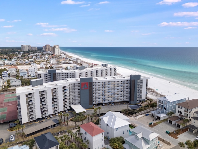 drone / aerial view featuring a water view, a view of city, and a beach view