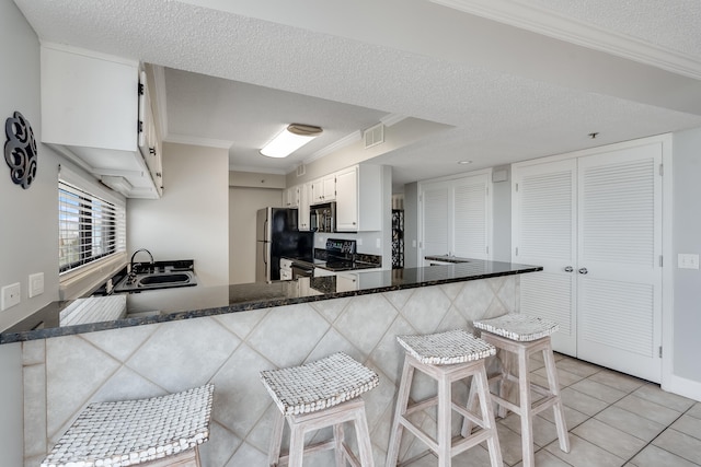 kitchen with crown molding, a sink, a peninsula, and black appliances