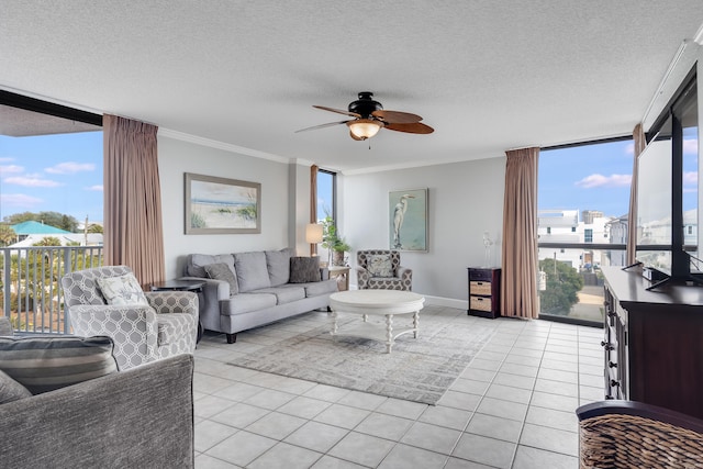 living area featuring a textured ceiling, ceiling fan, light tile patterned flooring, ornamental molding, and a wall of windows