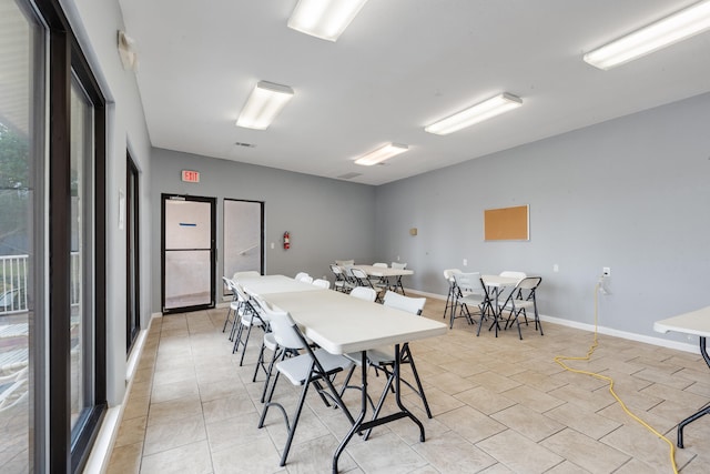 dining room with light tile patterned flooring and baseboards