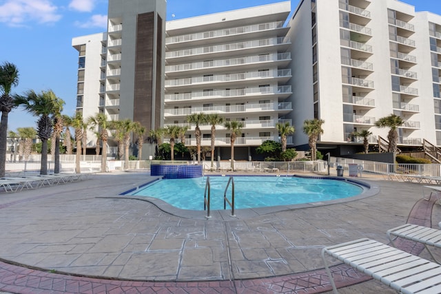 community pool featuring a patio area and fence