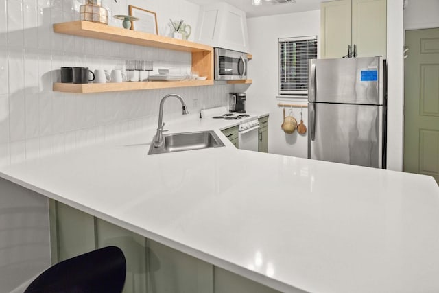 kitchen with decorative backsplash, stainless steel appliances, light countertops, open shelves, and a sink