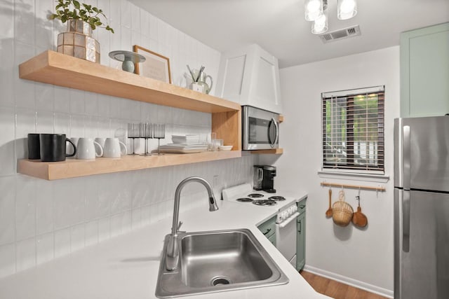 kitchen featuring visible vents, appliances with stainless steel finishes, light countertops, open shelves, and a sink