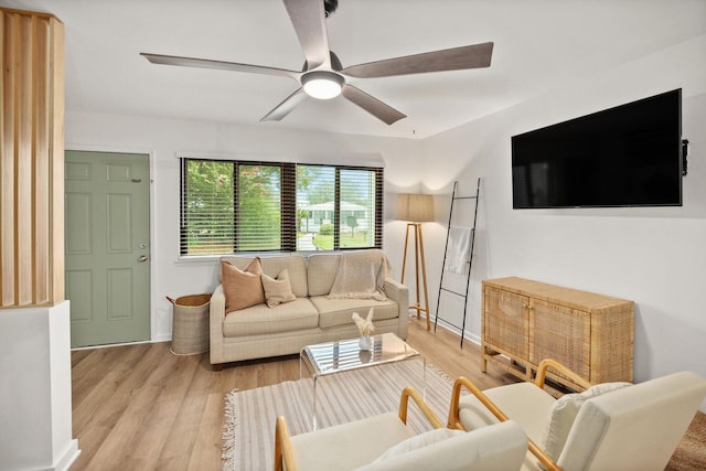 living area featuring a ceiling fan, light wood-style flooring, and baseboards