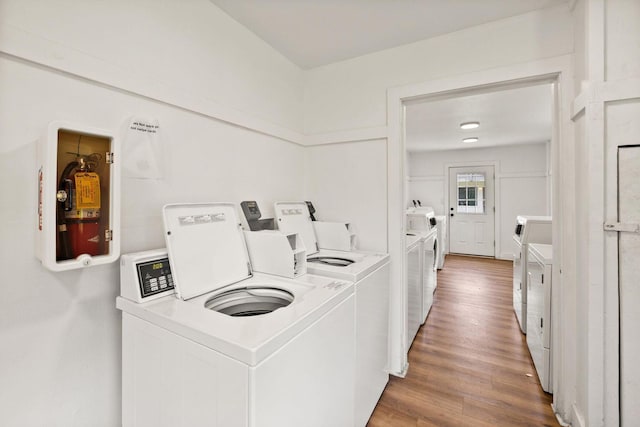 community laundry room with washing machine and dryer and wood finished floors