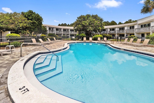 community pool featuring a patio area and fence