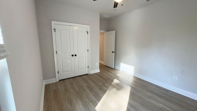 2720 Louis Cir, Crestview, FL 32536 - unfurnished bedroom featuring a closet, wood finished floors, and baseboards
