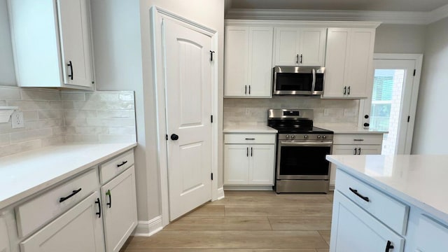 2720 Louis Cir, Crestview, FL 32536 - kitchen with white cabinetry, light wood finished floors, light countertops, and stainless steel appliances