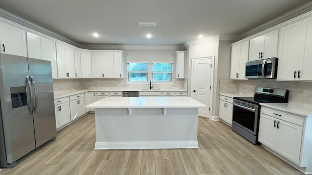 2720 Louis Cir, Crestview, FL 32536 - kitchen featuring a sink, white cabinetry, crown molding, a kitchen island, and stainless steel appliances