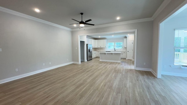 2720 Louis Cir, Crestview, FL 32536 - unfurnished living room with ornamental molding, a ceiling fan, plenty of natural light, and light wood-style floors