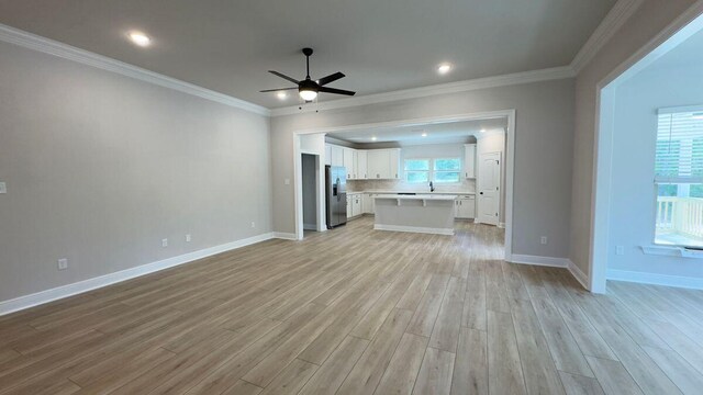 2720 Louis Cir, Crestview, FL 32536 - unfurnished living room featuring light wood finished floors, crown molding, a wealth of natural light, and a ceiling fan