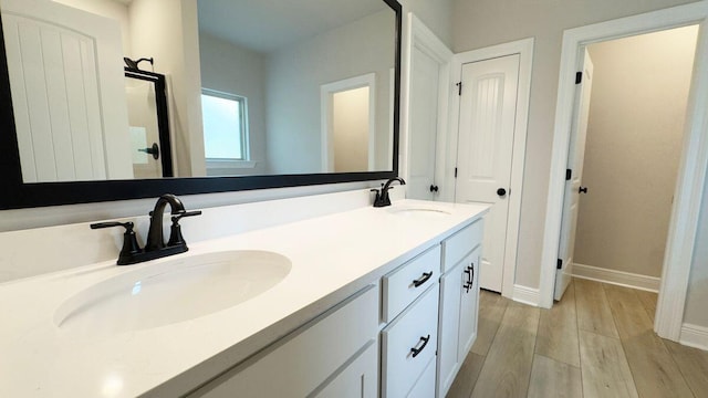 2720 Louis Cir, Crestview, FL 32536 - bathroom with a sink, double vanity, baseboards, and wood finished floors