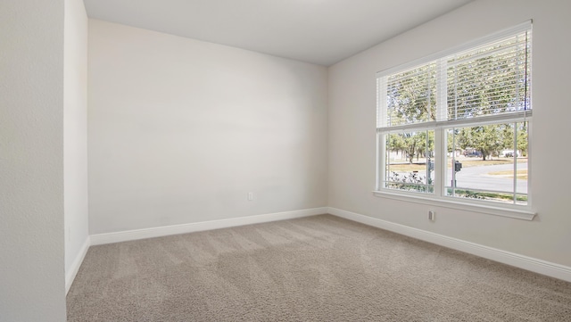 empty room with baseboards and light colored carpet