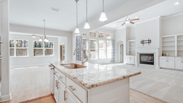 kitchen featuring visible vents, a ceiling fan, open floor plan, and a sink