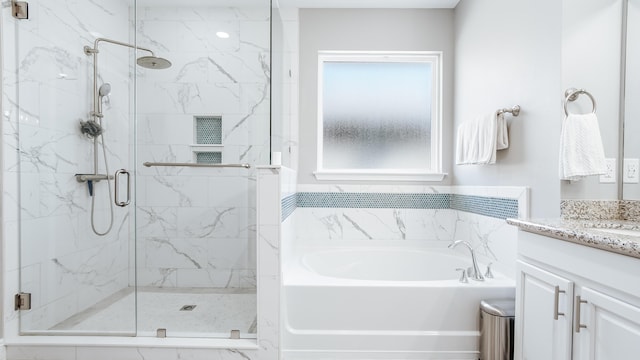 bathroom with a bath, a marble finish shower, and vanity