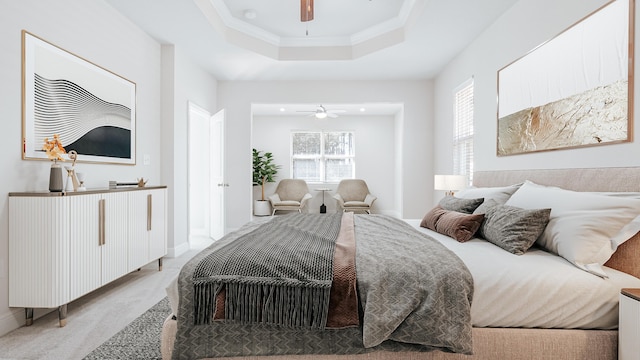bedroom with a tray ceiling, carpet floors, a ceiling fan, and baseboards